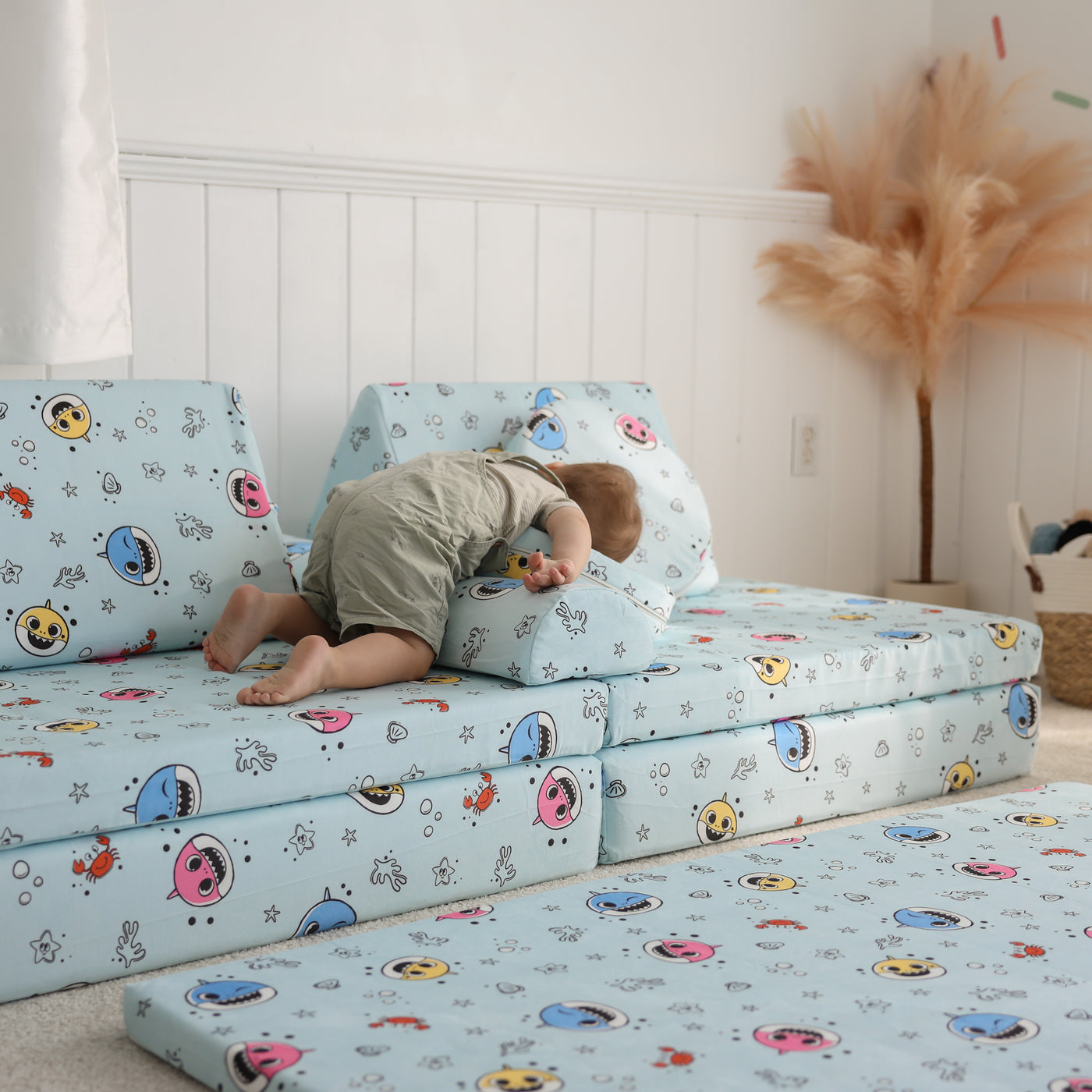 Toddler using Baby Shark™ x Roo & You™ Stepping Stones as a pillow while pretending to sleep.