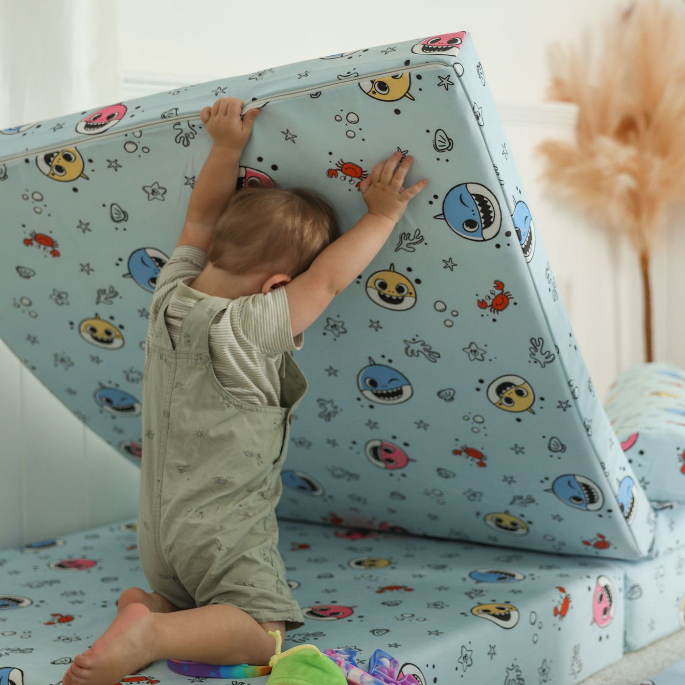 Kid lifting the Baby Shark™ x Roo & You™ Joey Play Couch base to build.