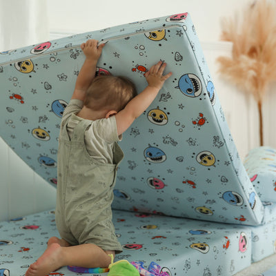 Kid lifting the Baby Shark™ x Roo & You™ Joey Play Couch base to build.