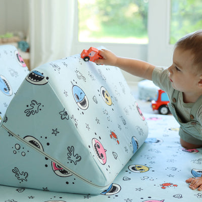 Toddler driving a toy car on the Baby Shark™ x Roo & You™ Joey Play Couch.